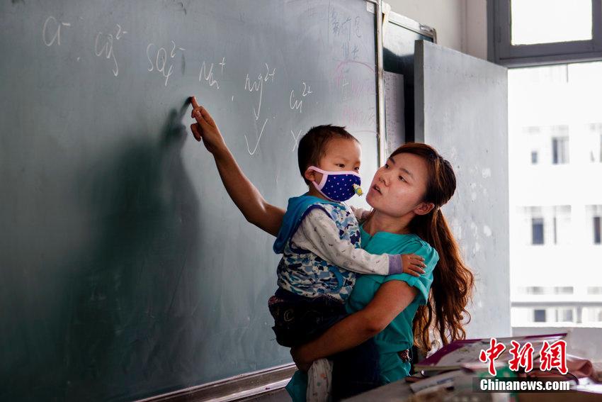 老師背著4個(gè)月女兒上課